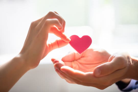 A person holding a heart in their hands